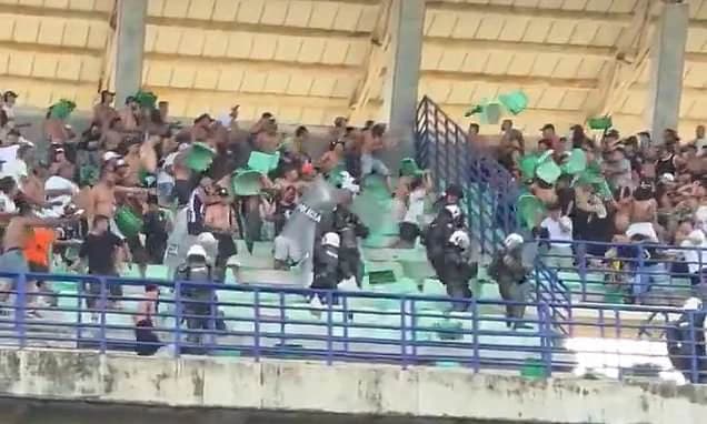 Brawling football fans rip out seats as riot police are called in and match is suspended - with near